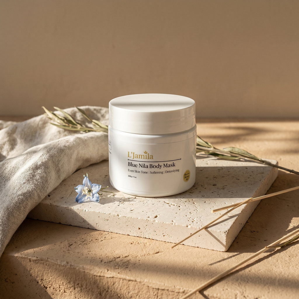 Blue Nila Body Mask jar on travertine slab with linen, dried blue flowers, and dappled morning light.
