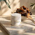 Moroccan Black Soap jar on limestone with glossy soap mound, wooden spatula, and dappled warm dawn light.