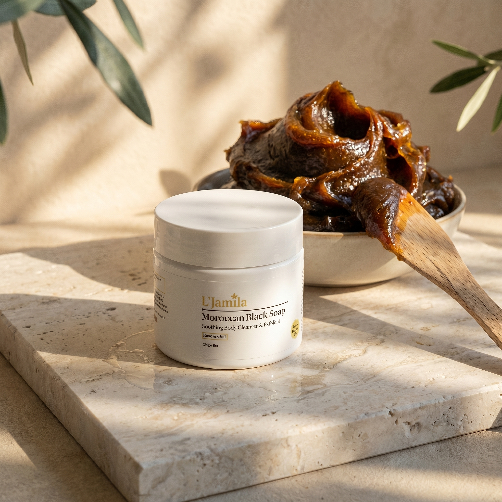 Moroccan Black Soap jar on limestone with glossy soap mound, wooden spatula, and dappled warm dawn light.